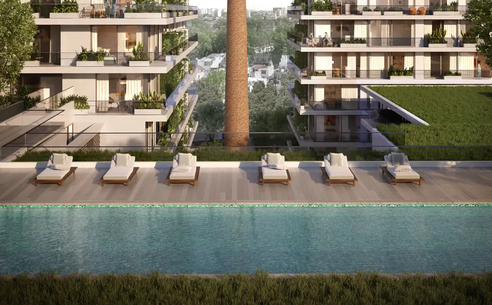 Piscina de 20 metros de Canvas Barracas, con la chimenea de fondo